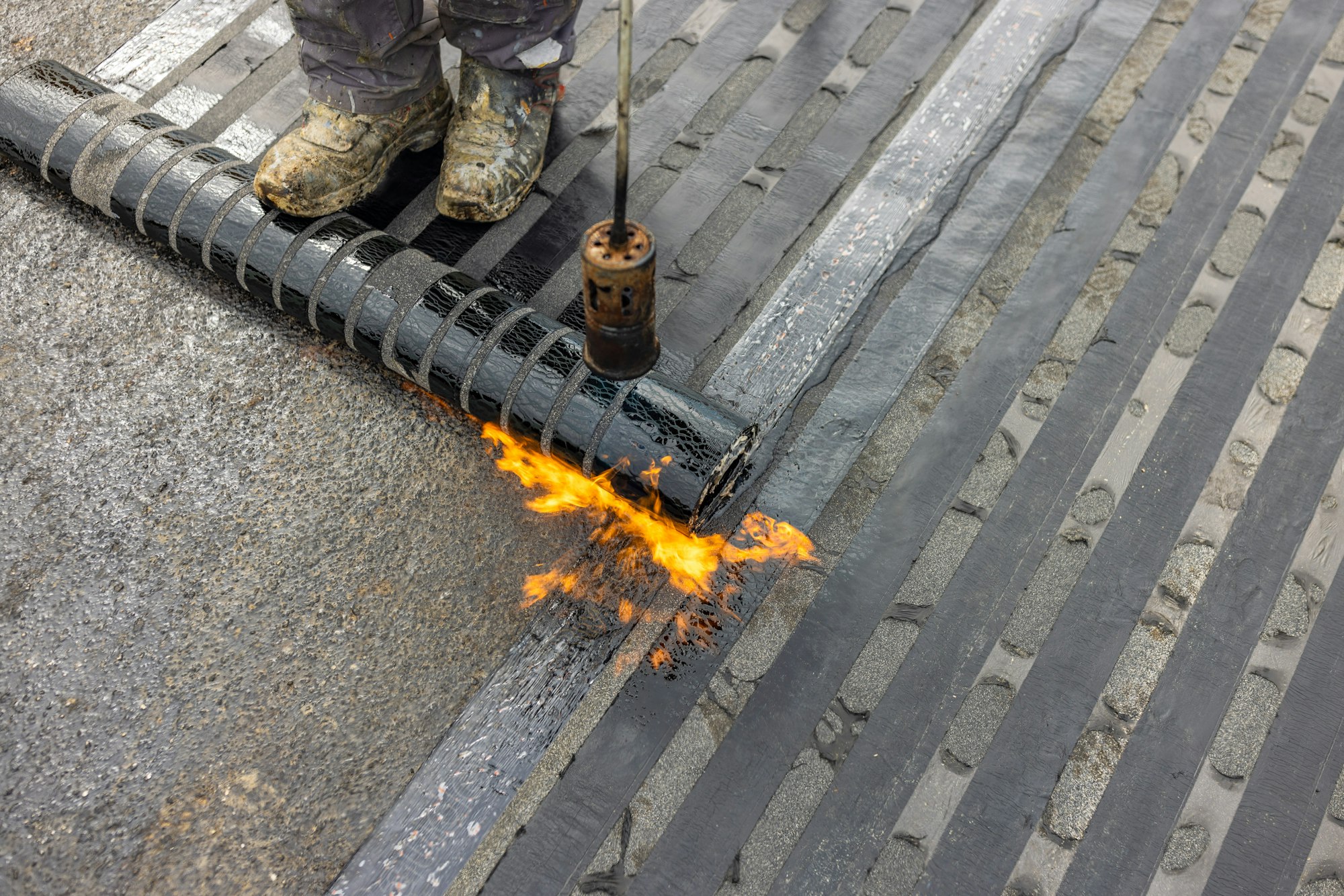 Bituminous membrane waterproofing system details and installation on flat rooftop.