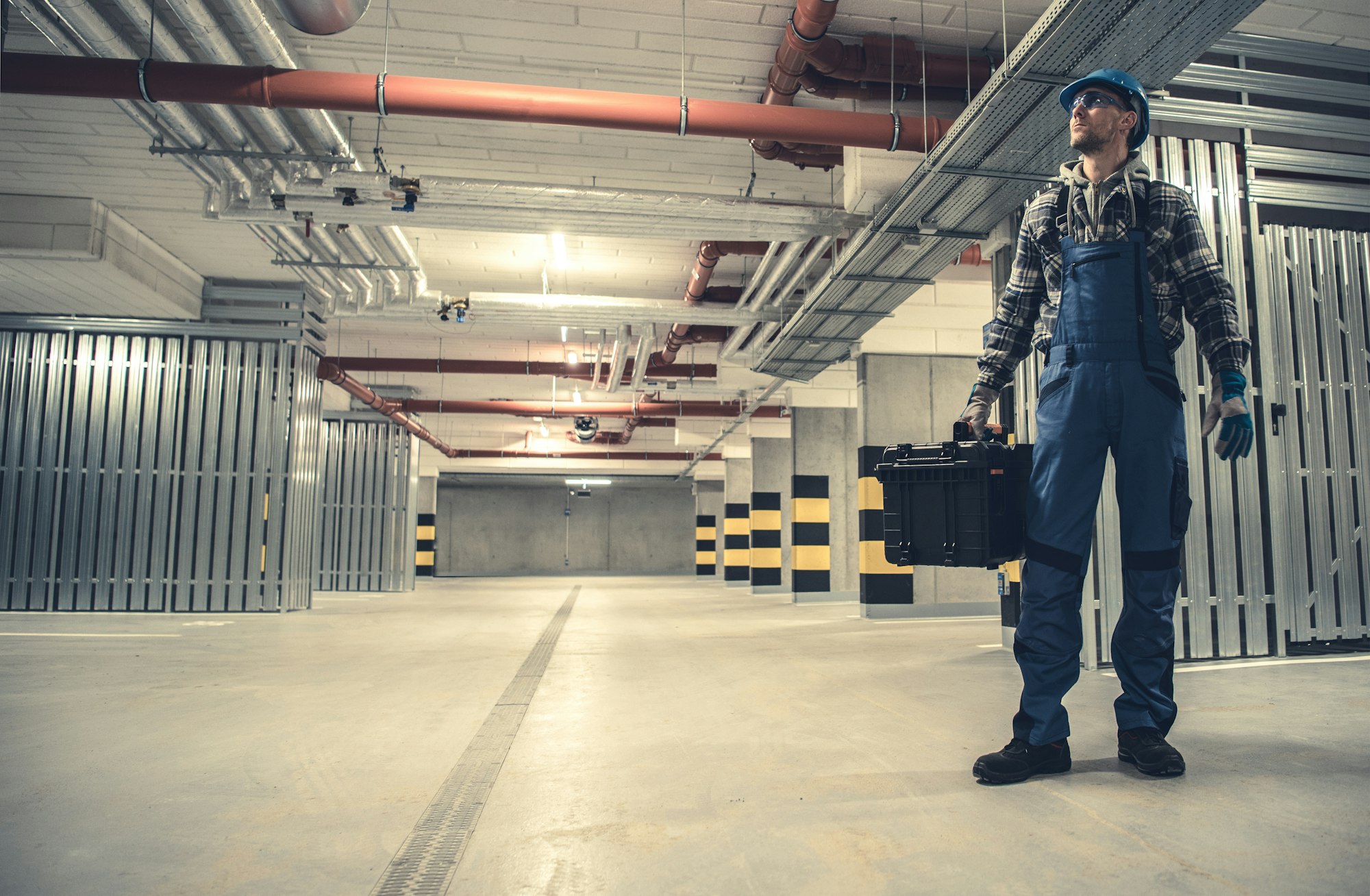 Blue Hard Hat Wearing Plumbing Contractor Worker with His Tools Box